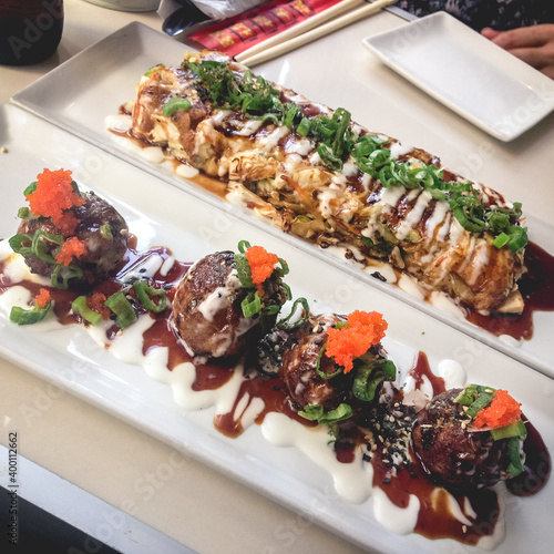 Delicious traditional japanese takoyaki and okonomiyaki omelette in a white plates photo