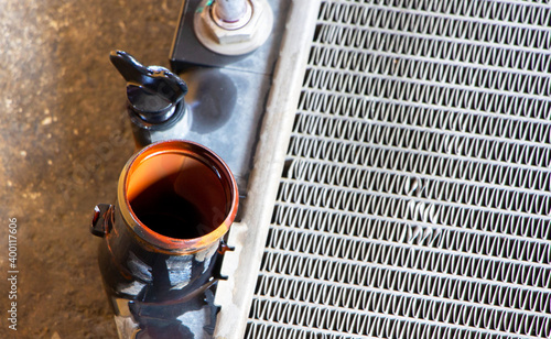  pipe of broken car radiator with a rusty color on a concrete. Focus on a rusty pipe