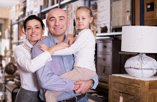 Portrait of smiling young family in furniture store.