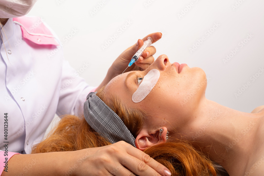 The beautician performs the facial injection procedure. Cosmetology and skin care, spa and beauty.