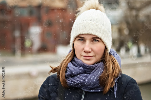 Portrait of a young beautiful happy smiling girl on the background of the city. Winter fashion, Christmas holidays concept.