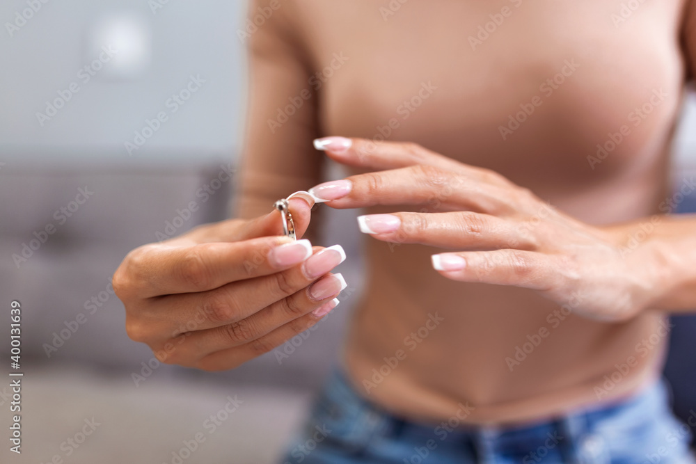 Young upset depressed lonely pensive divorced woman worrying about failed marriage and remove the ring from the finger after break up relationship and divorce Young upset depressed lonely pensive divorced woman worrying about failed marriage and remove the ring from the finger after break up relationship and divorce