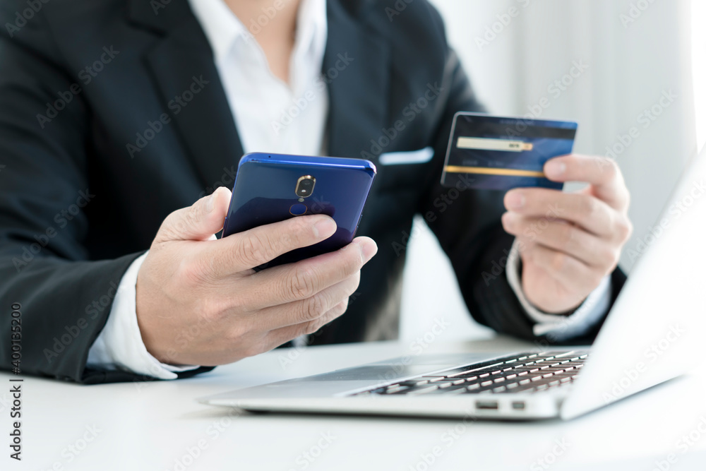 Online Payments Man's hands hold a smartphone and use credit cards to shop online, article websites, blogs, e-commerce sites. Online Payments Man's hands hold a smartphone and use credit cards to shop online, article websites, blogs, e-commerce sites.