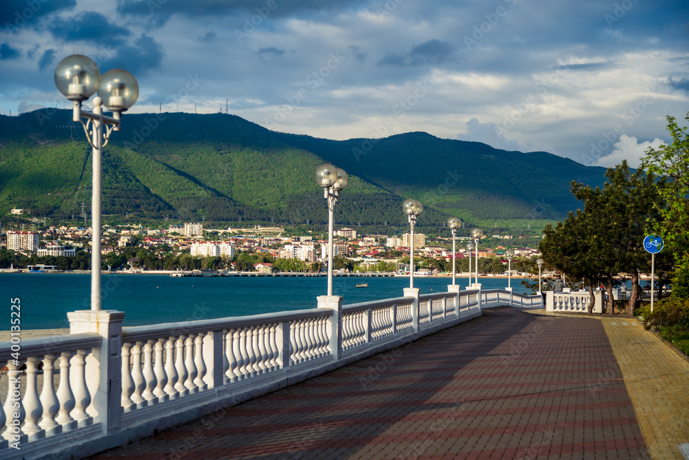 The embankment of the resort of Gelendzhik goes into the distance along the steep Bank of the Gelendzhik Bay. Beautiful evening perspective of the balustrade in the evening twilight