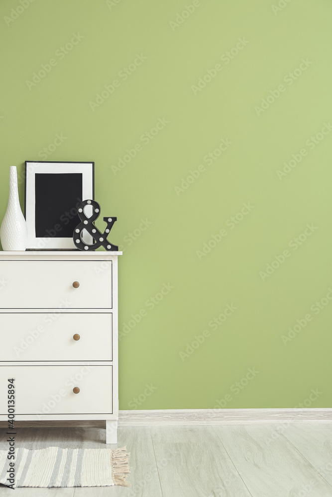 Modern chest of drawers near color wall in room