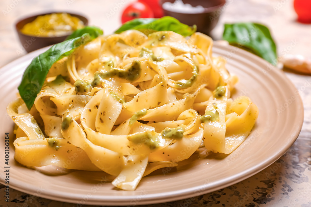 Plate with tasty pasta and pesto sauce on table, closeup