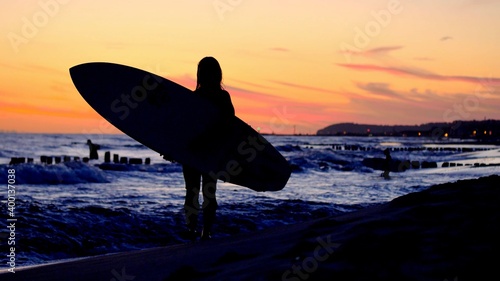 Silhouette of Surfer with Surfboard on Baltic Sea Beach after Sunset Slow Motion