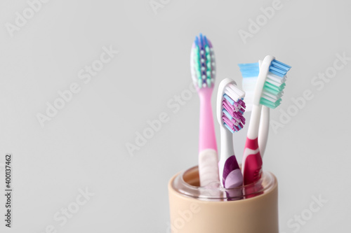 Holder with toothbrushes on light background