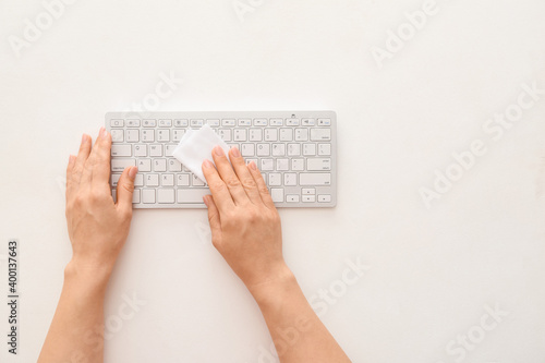 Woman cleaning computer keyboard on white background