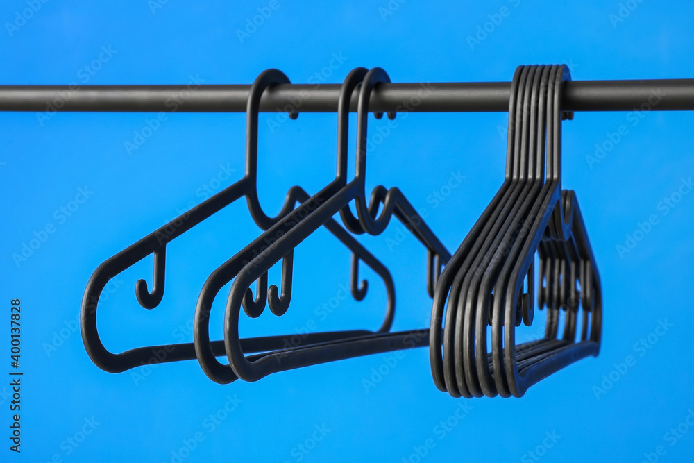 Rack with clothes hangers on color background Rack with clothes hangers on color background