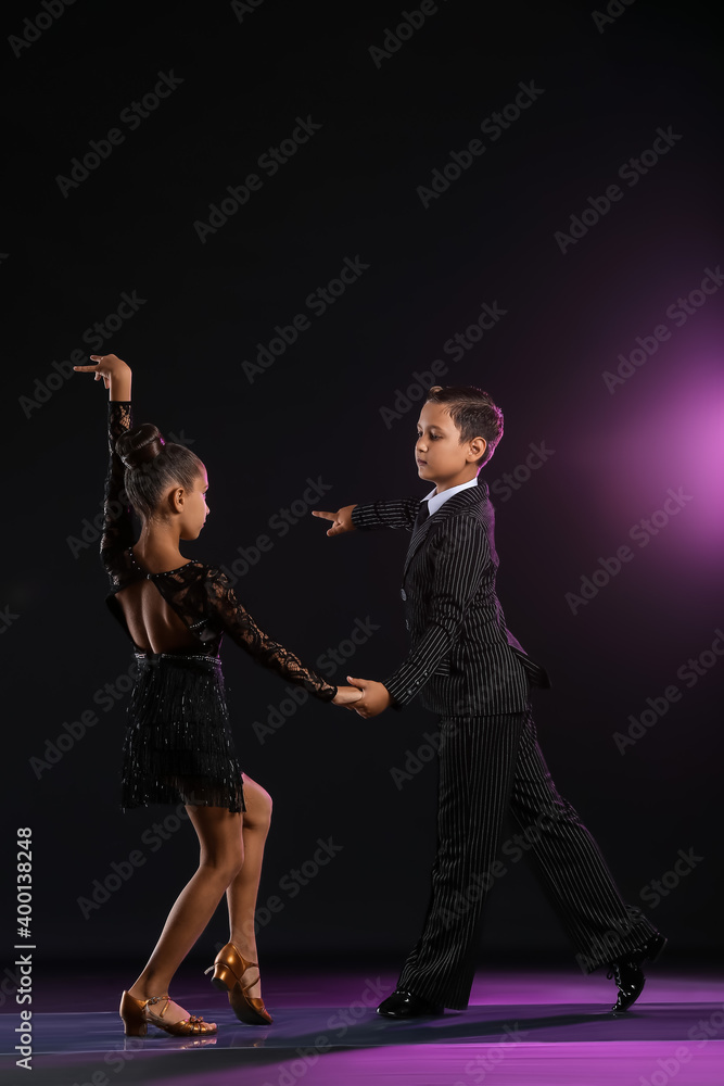 Cute little children dancing against dark background Cute little children dancing against dark background