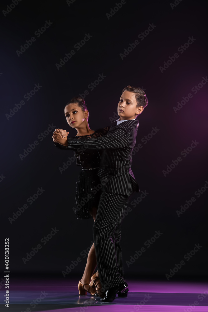 Cute little children dancing against dark background Cute little children dancing against dark background