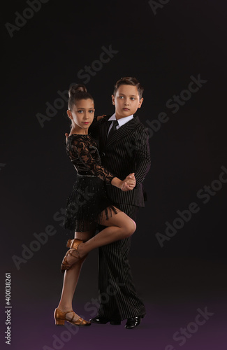 Cute little children dancing against dark background