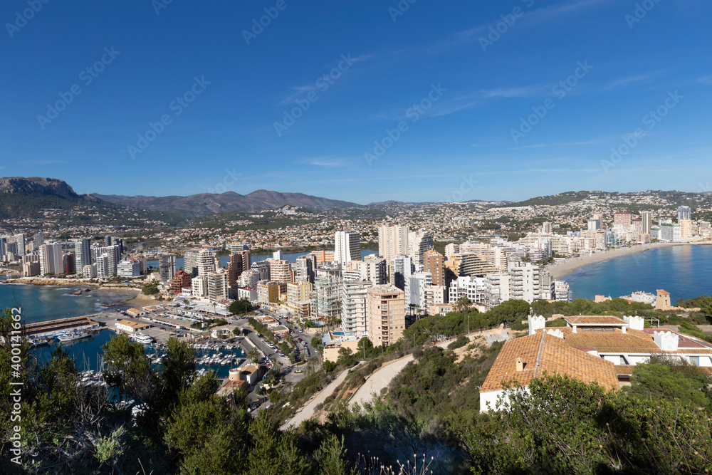Fototapeta premium Coastline of the Mediterranean resort of Calpe, Spain with sea and yachts, lake, skyscrapers and mountain range.