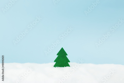 Green christmas tree on blue background with fake snow 