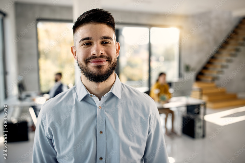 Portrait of young happy businessman in the office. Portrait of young happy businessman in the office.