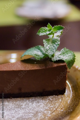 Piece of chocolate cheesecake with berries on dark background, close up photo