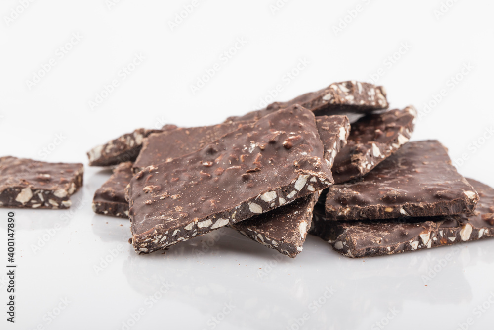 Broken chocolate chips pieces isolated on white background Broken chocolate chips pieces isolated on white background