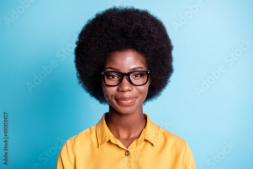 Photo of dark skin big volume hairdo woman smiling straight nice calm look camera cute lovely face optics shop costumer wear eyeglasses yellow shirt isolated blue color background