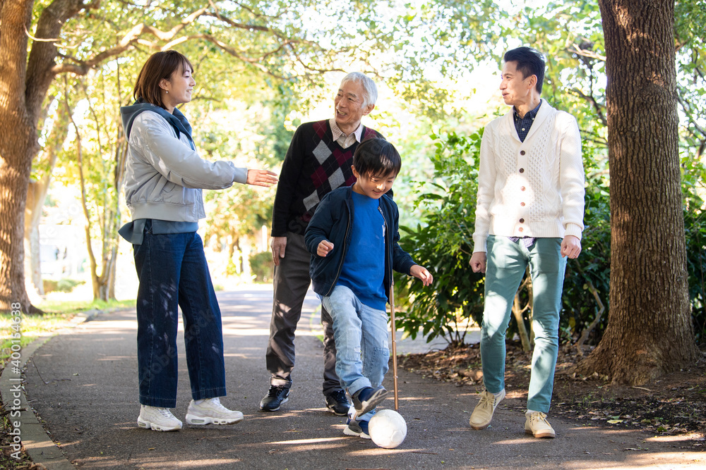 Obraz premium 若い親子と夫婦が仲良く公園で散歩をしている