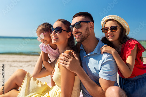 family, leisure and people concept - happy mother, father and two daughters on summer beach © Syda Productions