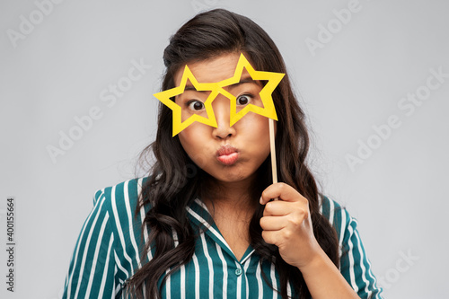 party props  photo booth and people concept - asian young woman with big glasses in shape of stars over grey background