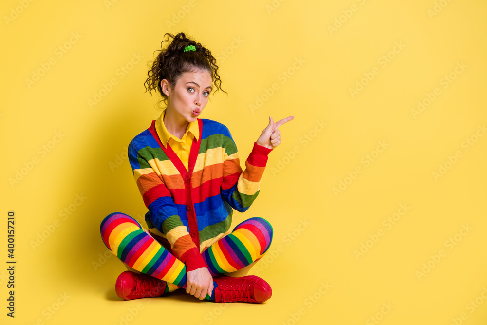 Full body photo of girl sit floor point finger copyspace wear striped clothes isolated on shine color background Full body photo of girl sit floor point finger copyspace wear striped clothes isolated on shine color background