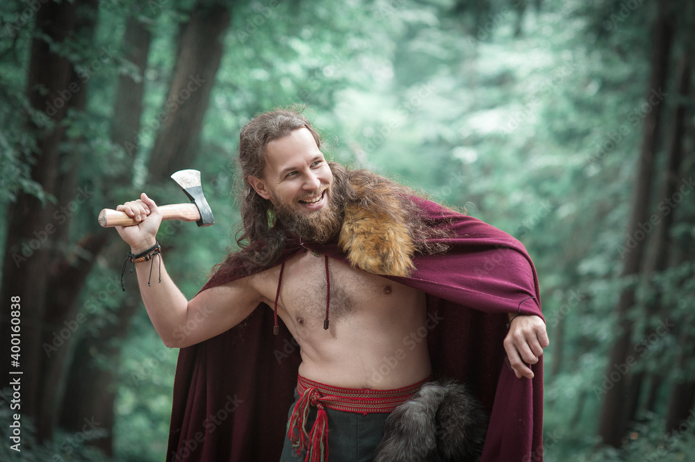 Warrior Viking man with iron axe screaming outdoor