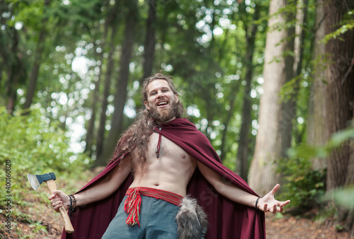 Warrior Viking man with iron axe screaming outdoor