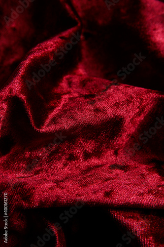 Red velvet material background. Beautiful swirl fabric texture