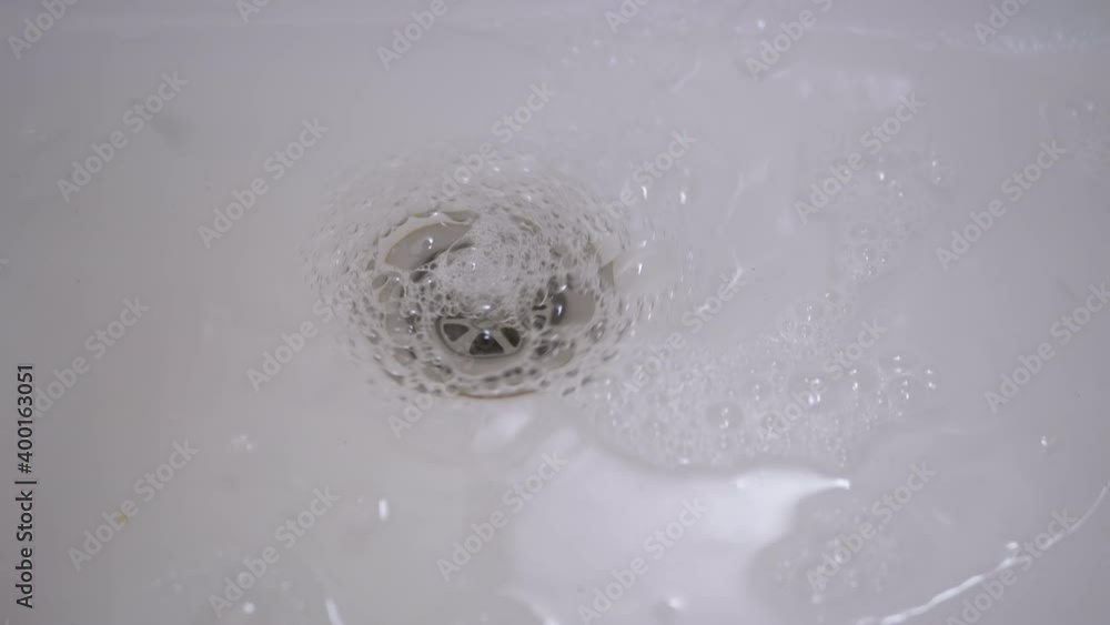 Drain Hole in Sink is Clogged. Bubbling Water Pours Into a Clogged