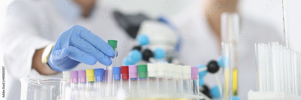 Researcher takes out an empty test tube from tray. Equipment and reagents for chemical analysis concept Researcher takes out an empty test tube from tray. Equipment and reagents for chemical analysis concept