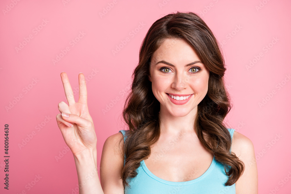 Portrait of optimistic sweet brunette hair style girl show v-sign wear blue top isolated on pink color background Portrait of optimistic sweet brunette hair style girl show v-sign wear blue top isolated on pink color background