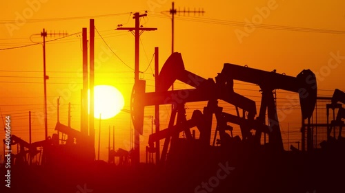 The sun rises behind oil pumps in California