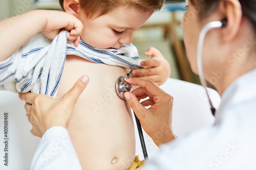 Kinderärztin beim Abhören von Lunge mit Stethoskop photo