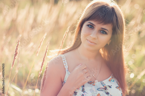 Caucasian girl posing in summer at sunset in the field