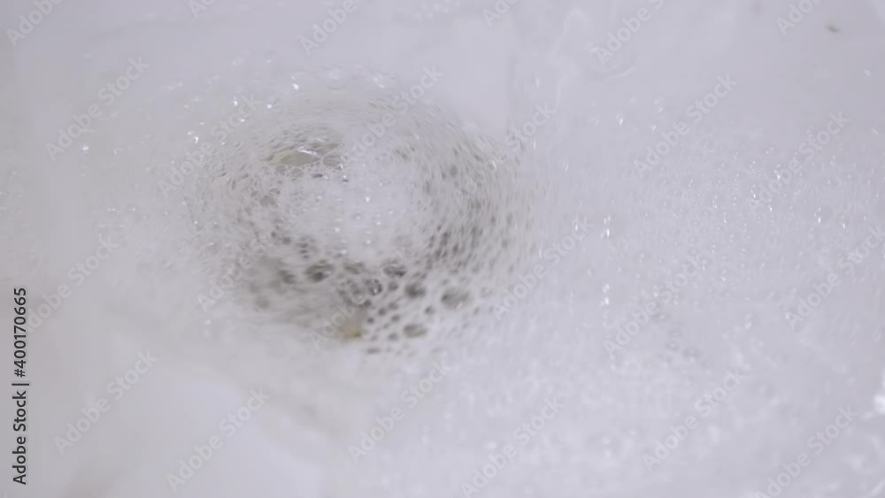 Drain Hole in Sink is Clogged. Bubbling Water Pours Into a Clogged White Sink Drain Hole in Sink is Clogged. Bubbling Water Pours Into a Clogged White Sink