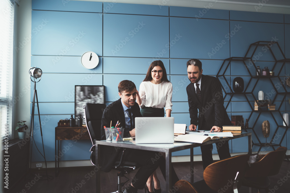 Business group in office using laptop and smiling Business group in office using laptop and smiling