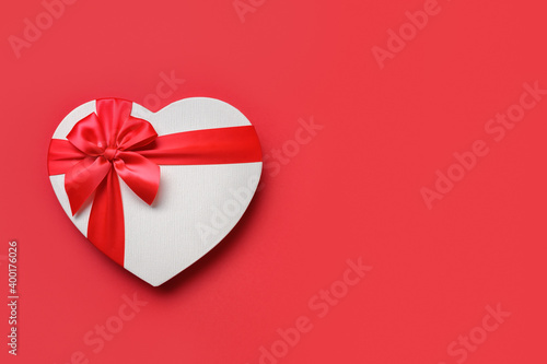 Red white gift in shaped of heart isolated on red background. Top view. Flat lay. Valentines day greeting card with space for text.