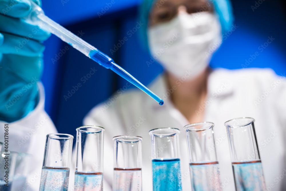 Laboratory worker mixes two substances in a test tube Laboratory worker mixes two substances in a test tube