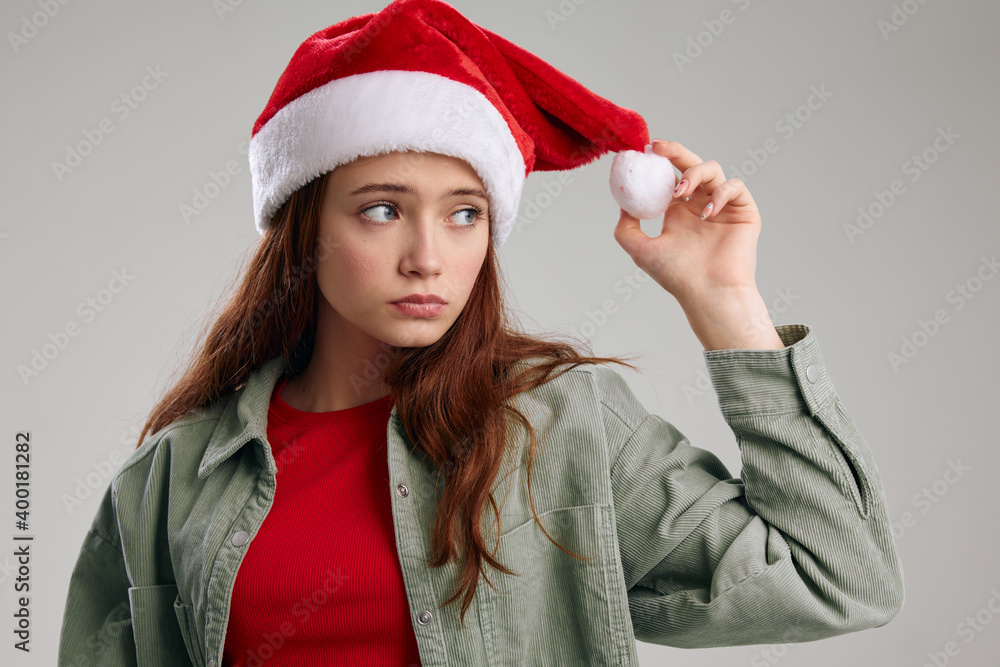 portrait of a girl in a New Year's hat and jacket on a gray background portrait of a girl in a New Year's hat and jacket on a gray background