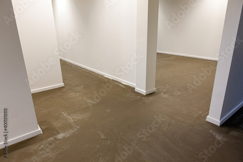 An empty new room with a new clean concrete floor, ready to be painted or made into a synthetic cast floor installation.