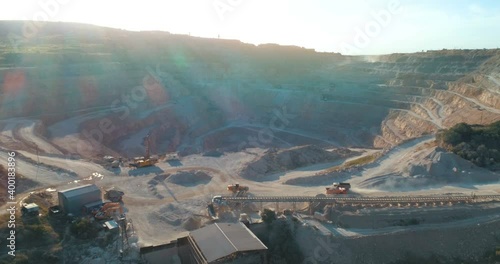 Aerial view of opencast mining quarry with lots of machinery at work - view from above. 