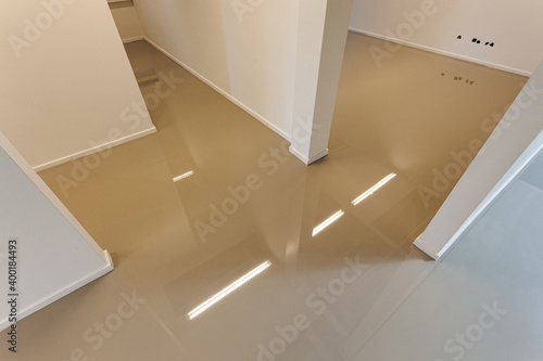 An indoor floor with a freshly added coating layer to create a synthetic cast floor installation.
