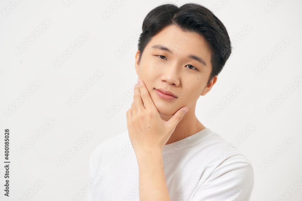 Close up portrait of a young man looking at camera with hand on chin isolated Close up portrait of a young man looking at camera with hand on chin isolated