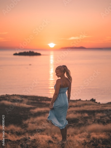 Woman on a hill watching the sunset over the ocean © Anas