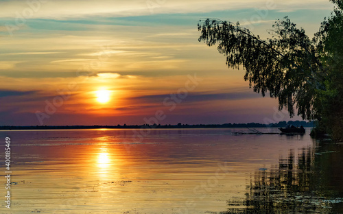 Summer landscape with the setting sun and clouds over the water. photo