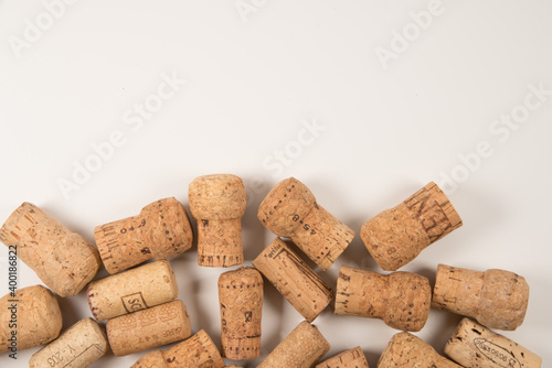 Used wine corks scattered randomly fill half frames on white background, space for text, isolated on white 