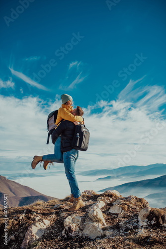 Photography happy couple man and woman tourist at top of mountain during a hike in summer