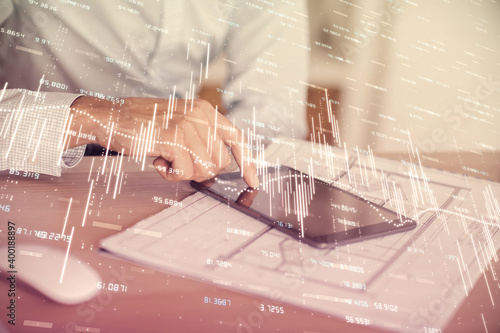 Double exposure of man s hands holding and using a digital device and forex graph drawing. Financial market concept.